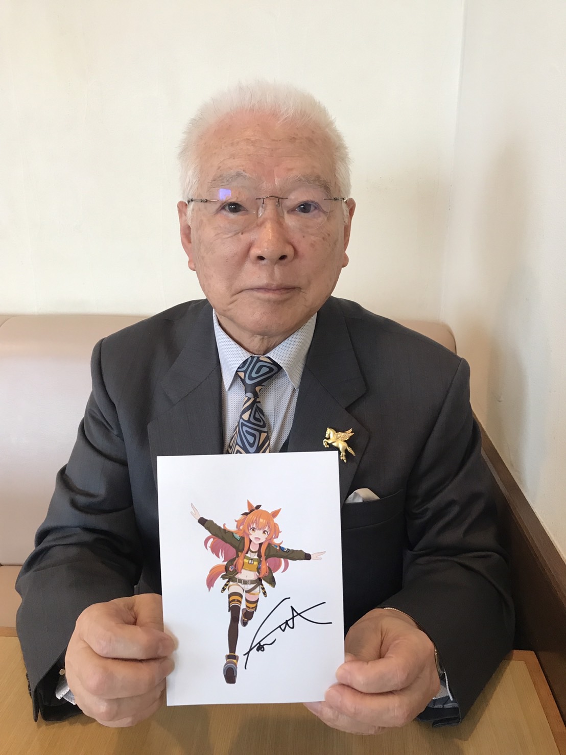 ウマ娘「マヤノトップガン」のイラストに自らのサインを添えた坂口正大元調教師（撮影・木村有三）