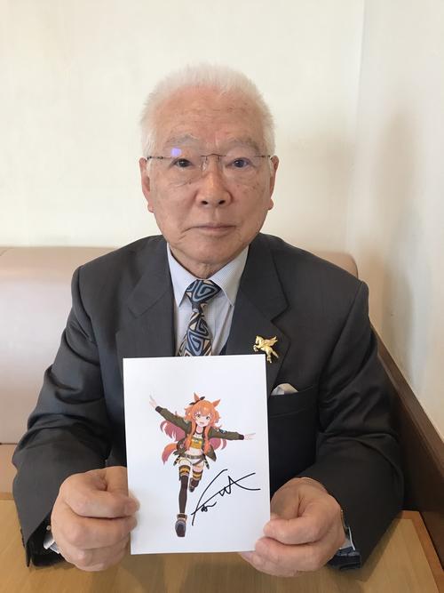 ウマ娘「マヤノトップガン」のイラストに自らのサインを添えた坂口正大元調教師(撮影・木村有三)