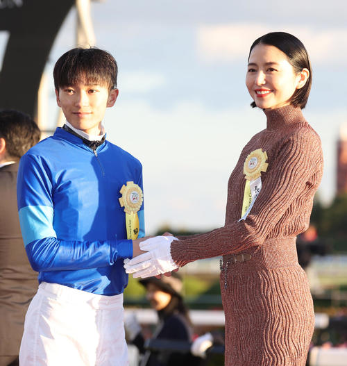 笑顔で握手する坂井騎手（左）とプレゼンターの長澤まさみ（撮影・白石智彦）