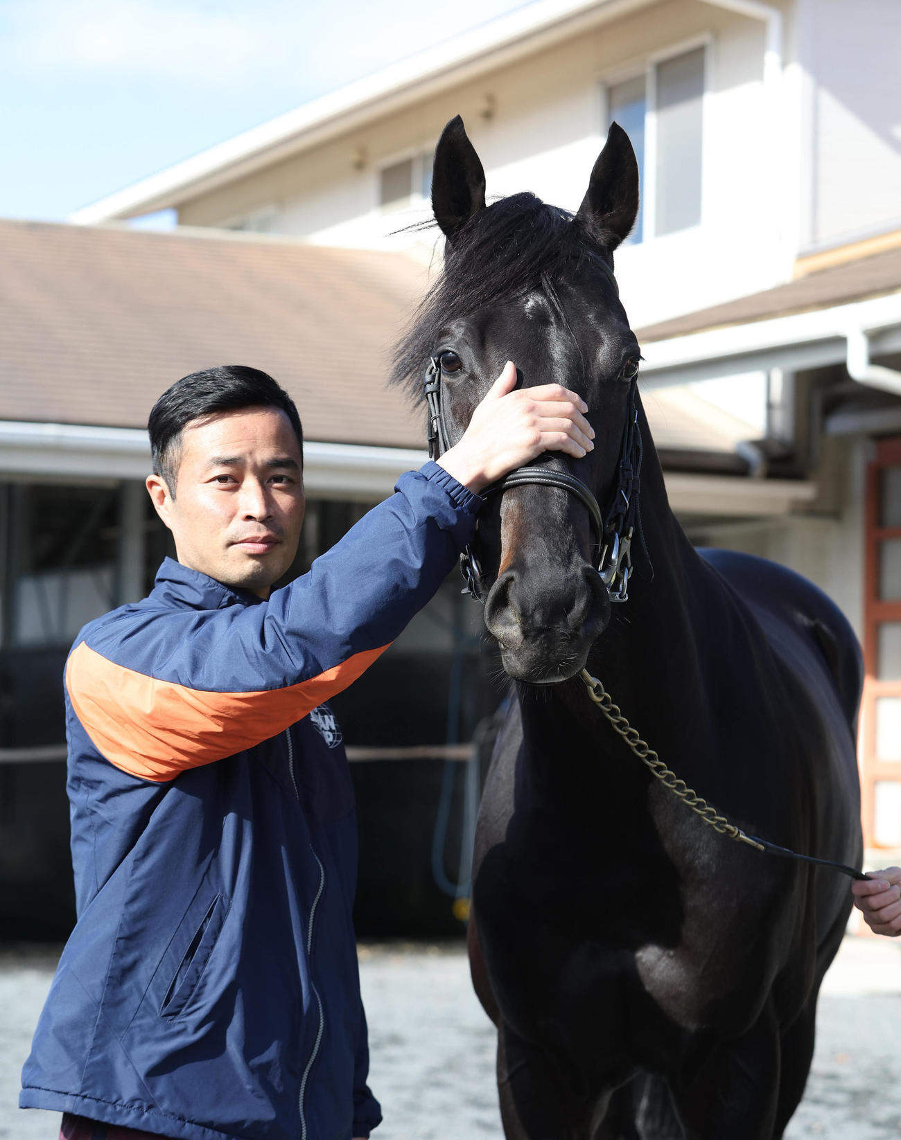厩舎で記念撮影する杉山晴調教師とジャスティンパレス