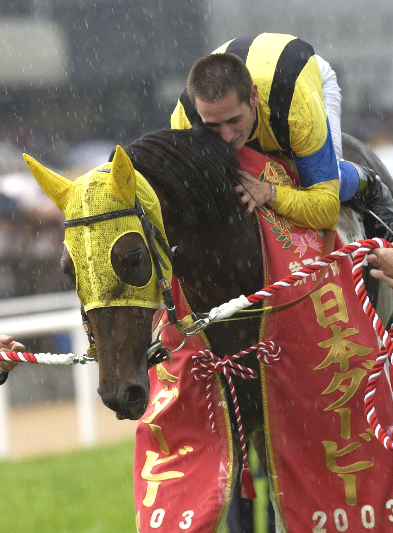 03年ダービーをネオユニヴァースで制したミルコ・デムーロ騎手は愛馬に抱きつく
