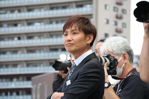 カメラマンが並ぶゴール前で管理馬のレースぶりを見届ける山崎誠士調教師