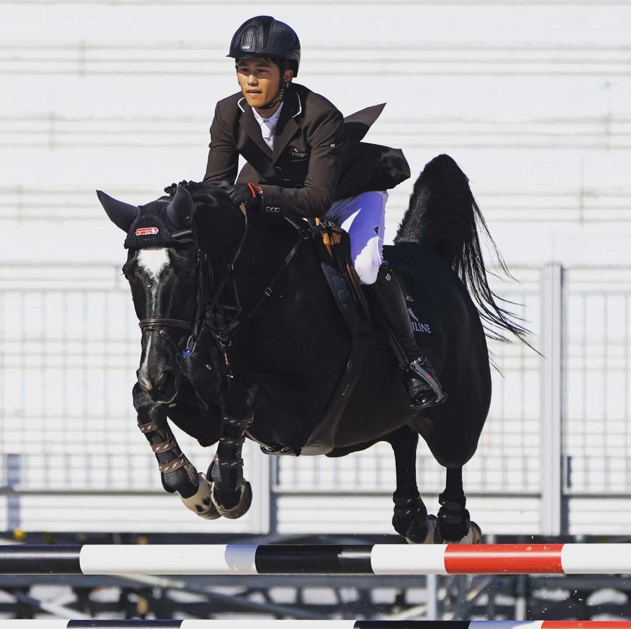 障害馬術で飛越を行う小牧加矢太騎手（本人提供）