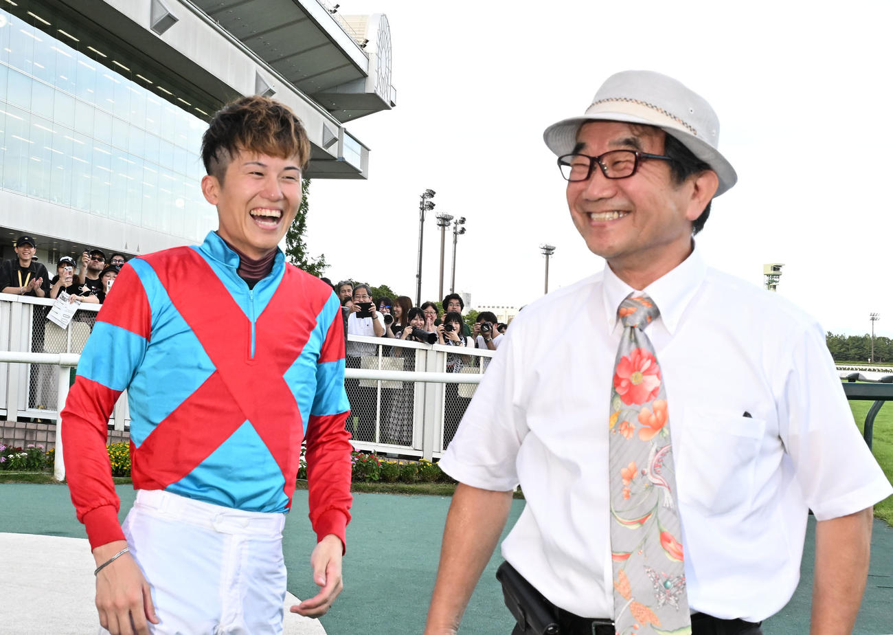 8月、新潟ジャンプSをインプレスで制し、佐々木調教師（右）と喜ぶ小牧騎手