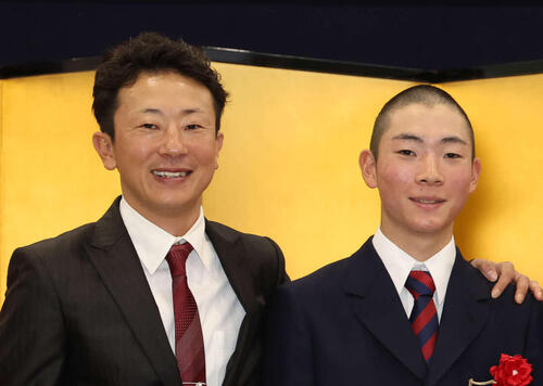 入学式を終えて写真に納まる石神深一騎手（左）と龍貴君