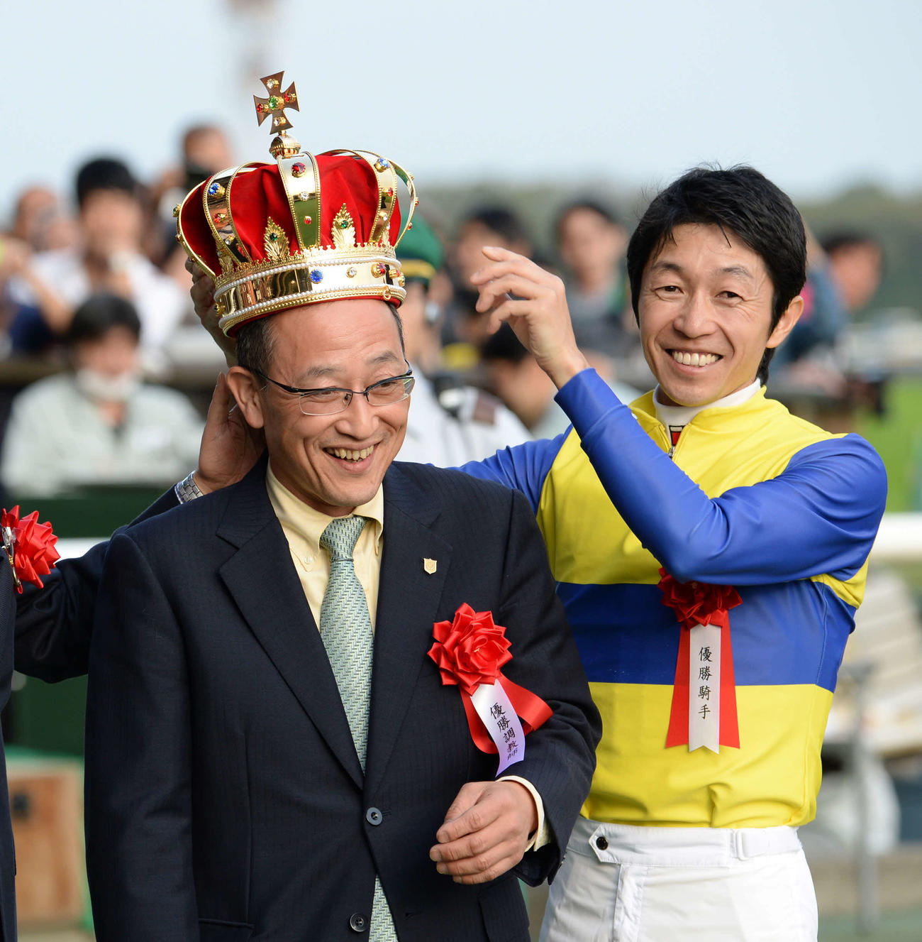 14年、エアソミュールで毎日王冠を制した武豊騎手（右）は角居師に王冠を載せて笑みを浮かべる