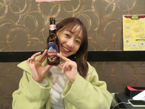 ネパールビールを手に笑顔の高田秋