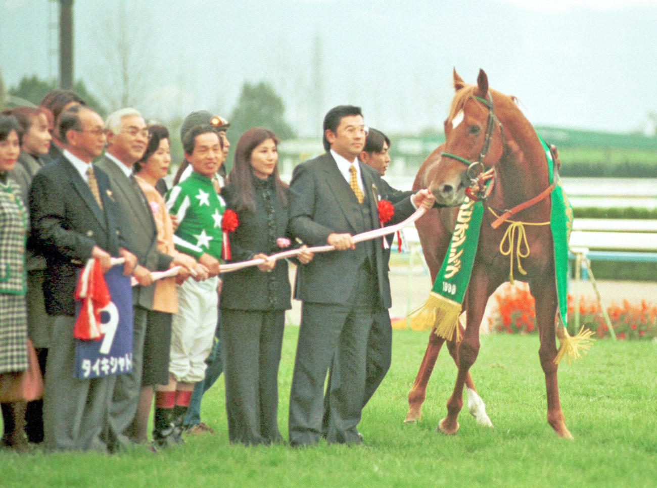 98年11月、マイルCSを制したタイキシャトルと岡部幸雄騎手（右から4人目）