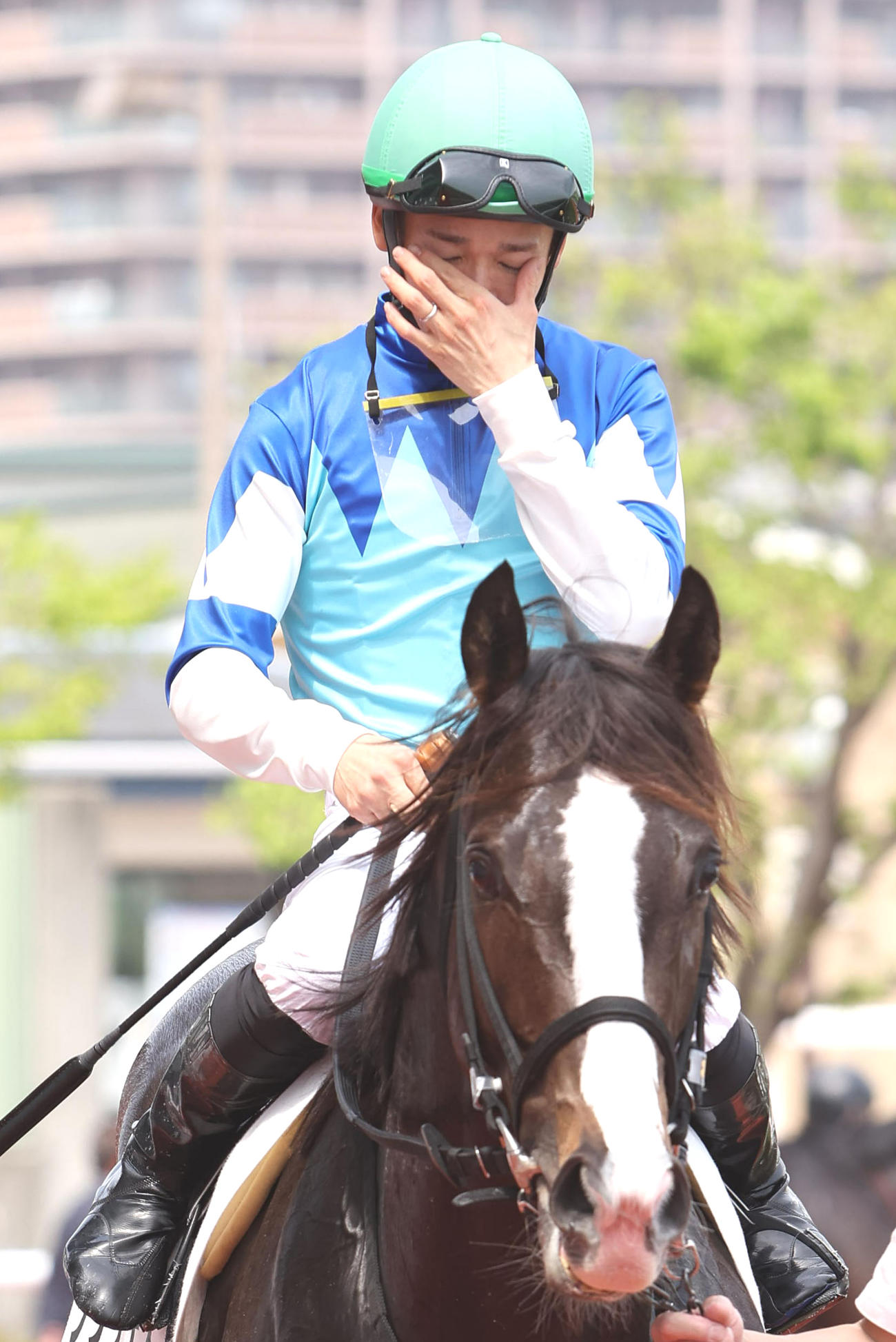 阪神2Rで復帰後初勝利を挙げ、目頭を押さえながら引き揚げる松山弘平騎手