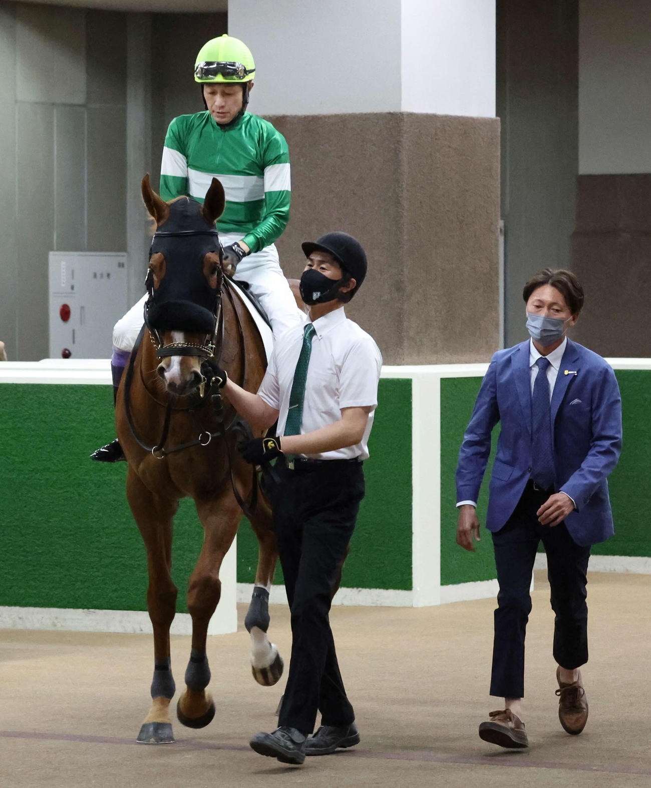 東京7R、蛯名正厩舎のダイナストーンに騎乗して馬場へ向かう武豊騎手。右は蛯名正師（撮影・丹羽敏通）