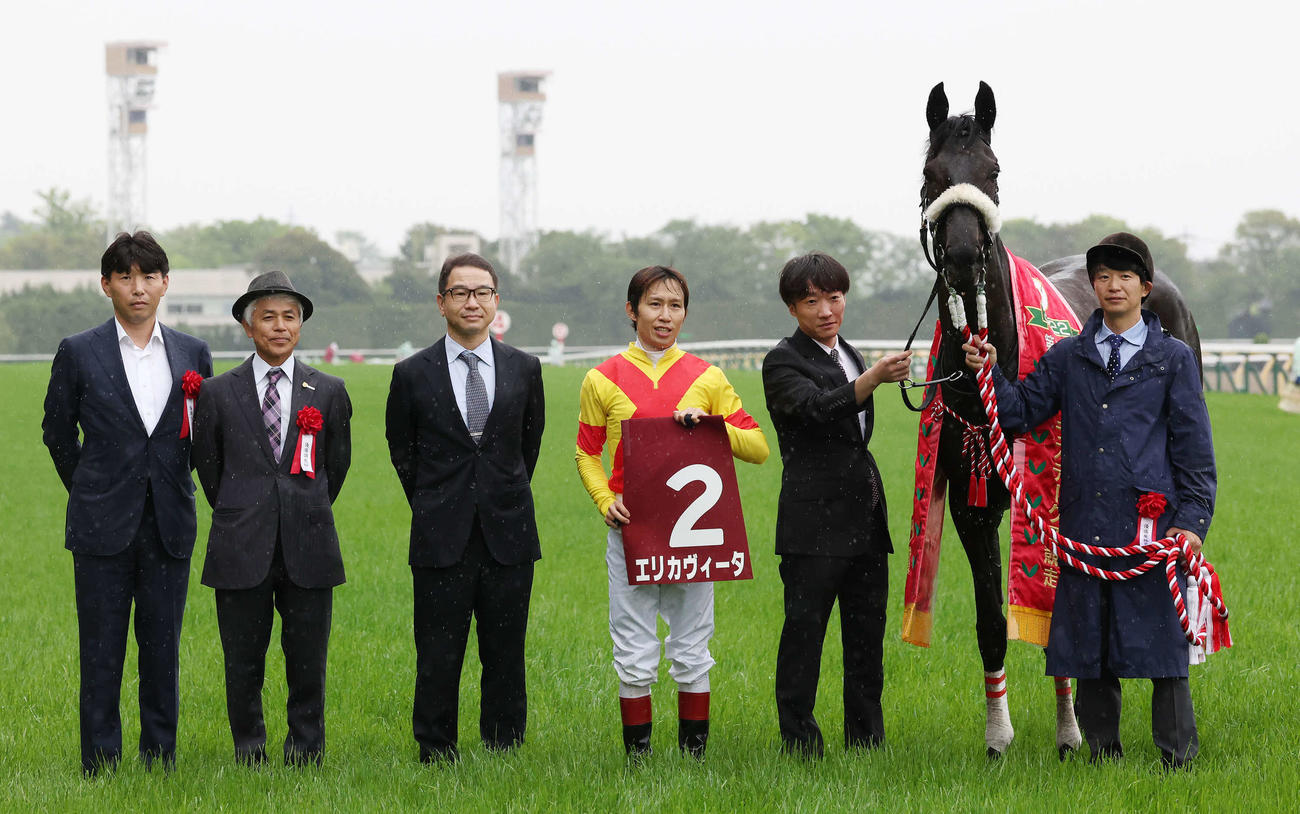 エリカヴィータの口取りをする国枝師（左から2人目）と田辺騎手（同4人目）（撮影・丹羽敏通）
