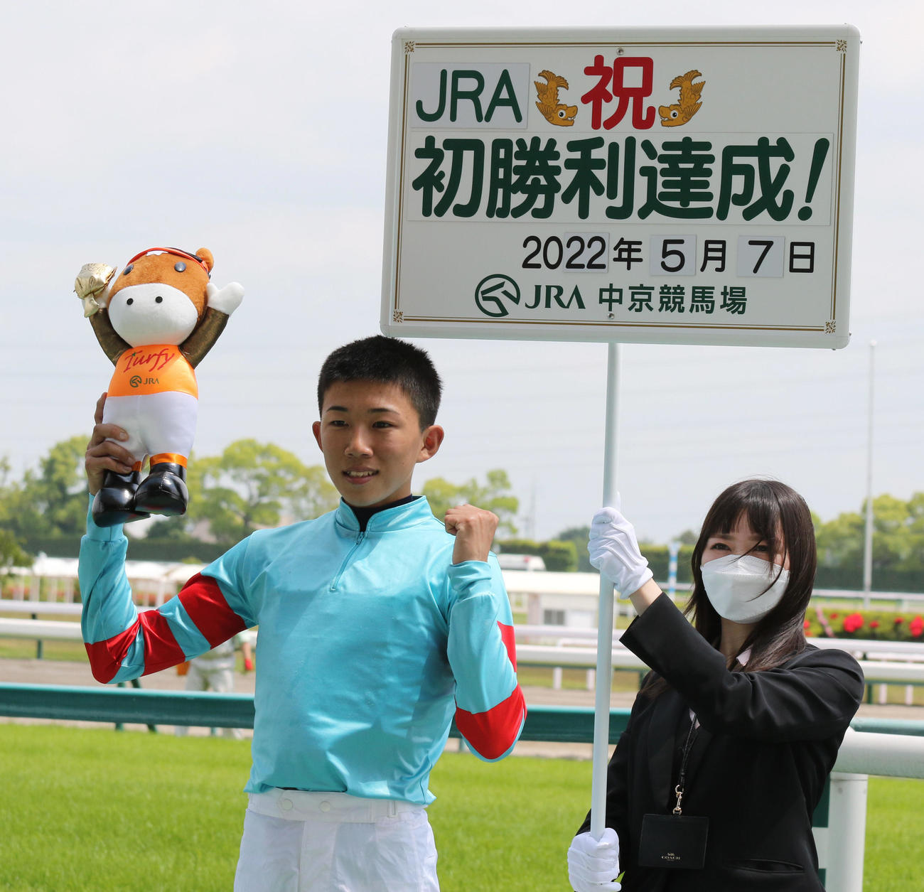 ヤマニンゼストでJRA初勝利を挙げ、ボードの前で笑顔を見せる鷲頭虎太騎手（撮影・渦原淳）