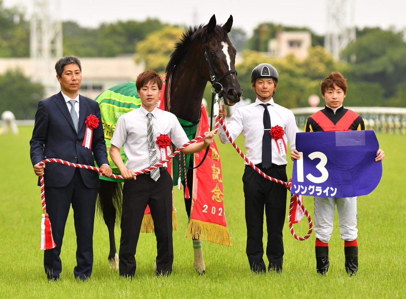 安田記念を制したソングラインの池添騎手（右端）と林調教師（左端）は記念撮影に納まる（撮影・柴田隆二）