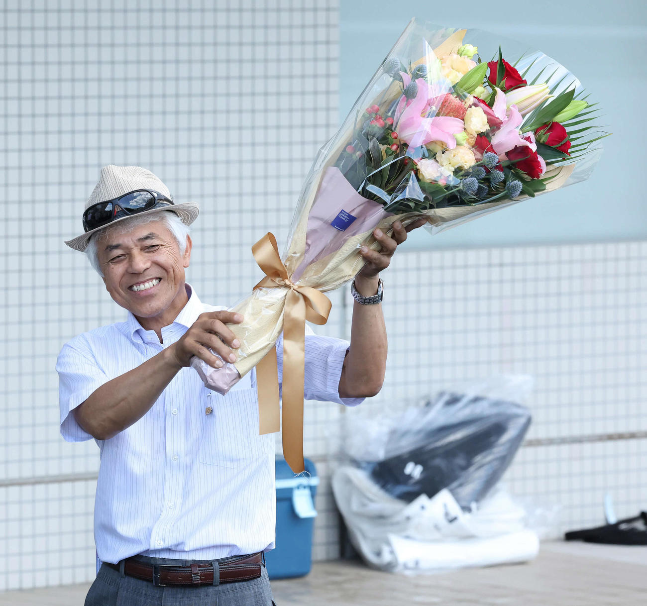 JRA通算1000勝を達成して花束を掲げる国枝師（撮影・丹羽敏通）