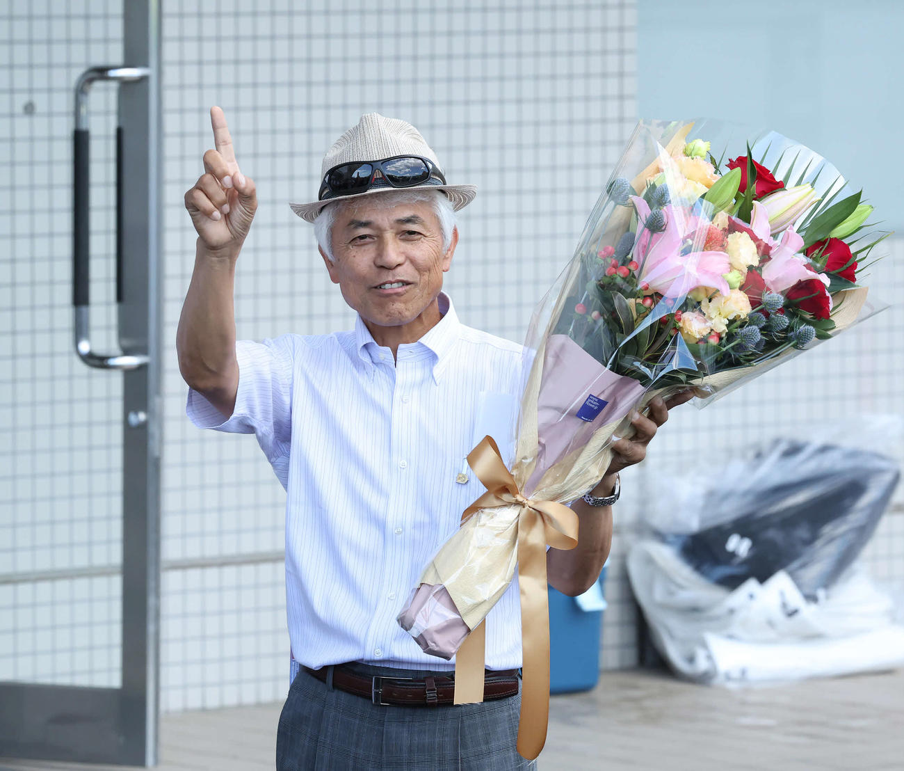函館10Rの洞爺湖特別でクライミングリリーが勝利し、JRA通算1000勝を達成して花束を掲げる国枝師（撮影・丹羽敏通）