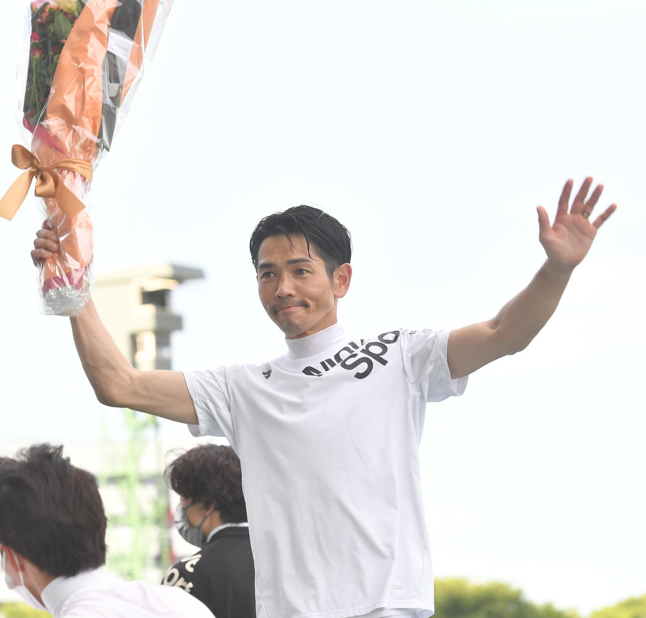夏の福島リーディングジョッキーに輝いた戸崎騎手は花束は花束を掲げた（撮影・柴田隆二）