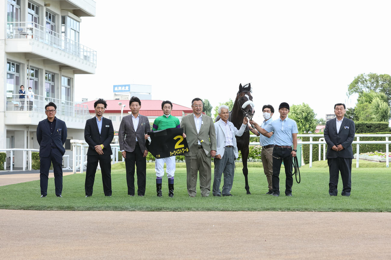 札幌日経オープンを制し写真に納まるハーツイストワールと武豊騎手（左から4人目）、関係者