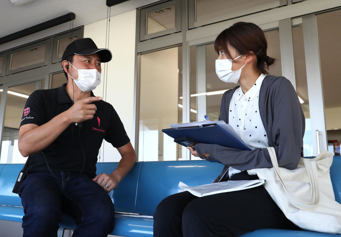 小崎師（左）にスマートファルコンの話を聞く下村記者（撮影・白石智彦）