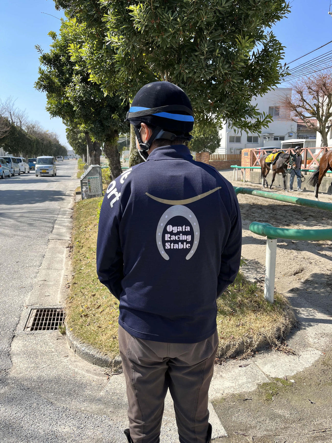 伊達政宗のかぶとをイメージした厩舎のロゴ入りジャージーを着る尾形師（2022年4月撮影）