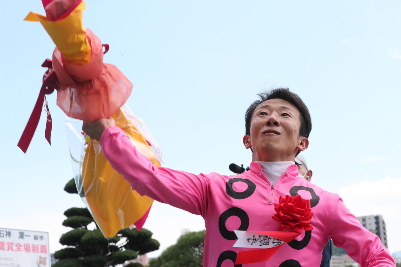 小倉サマーJ　アサクサゲンキで勝利した石神深一騎手は花束をファンに向かって投げ込む（撮影・梅根麻紀）