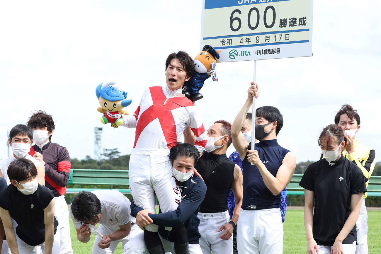中山6RでJRA通算600勝を達成し内田騎手に抱え上げられる丸山騎手（撮影・丹羽敏通）