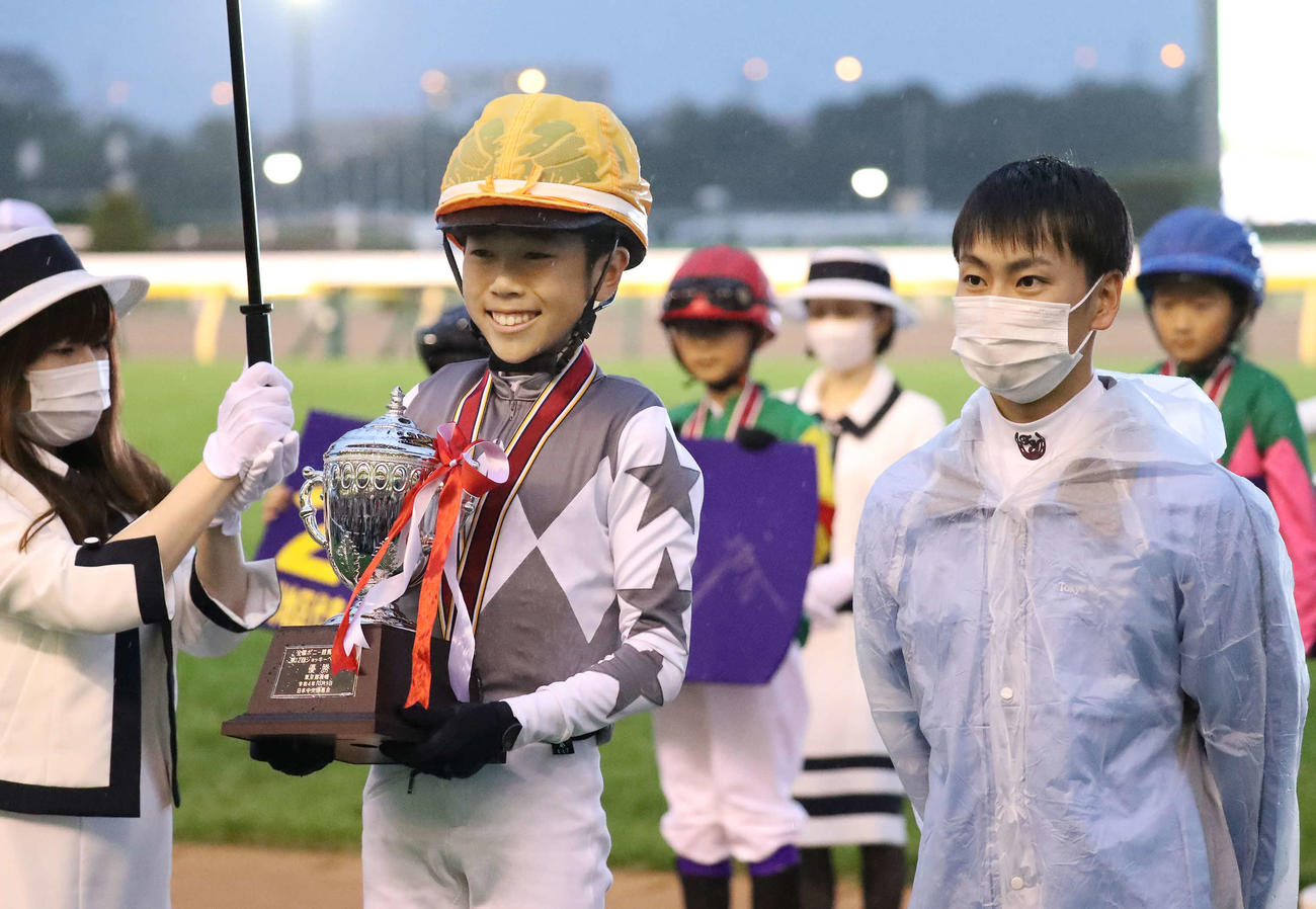 ジョッキーベイビーズで優勝しプレゼンターの横山武騎手（右）と写真に納まる松浦くん（撮影・丹羽敏通）