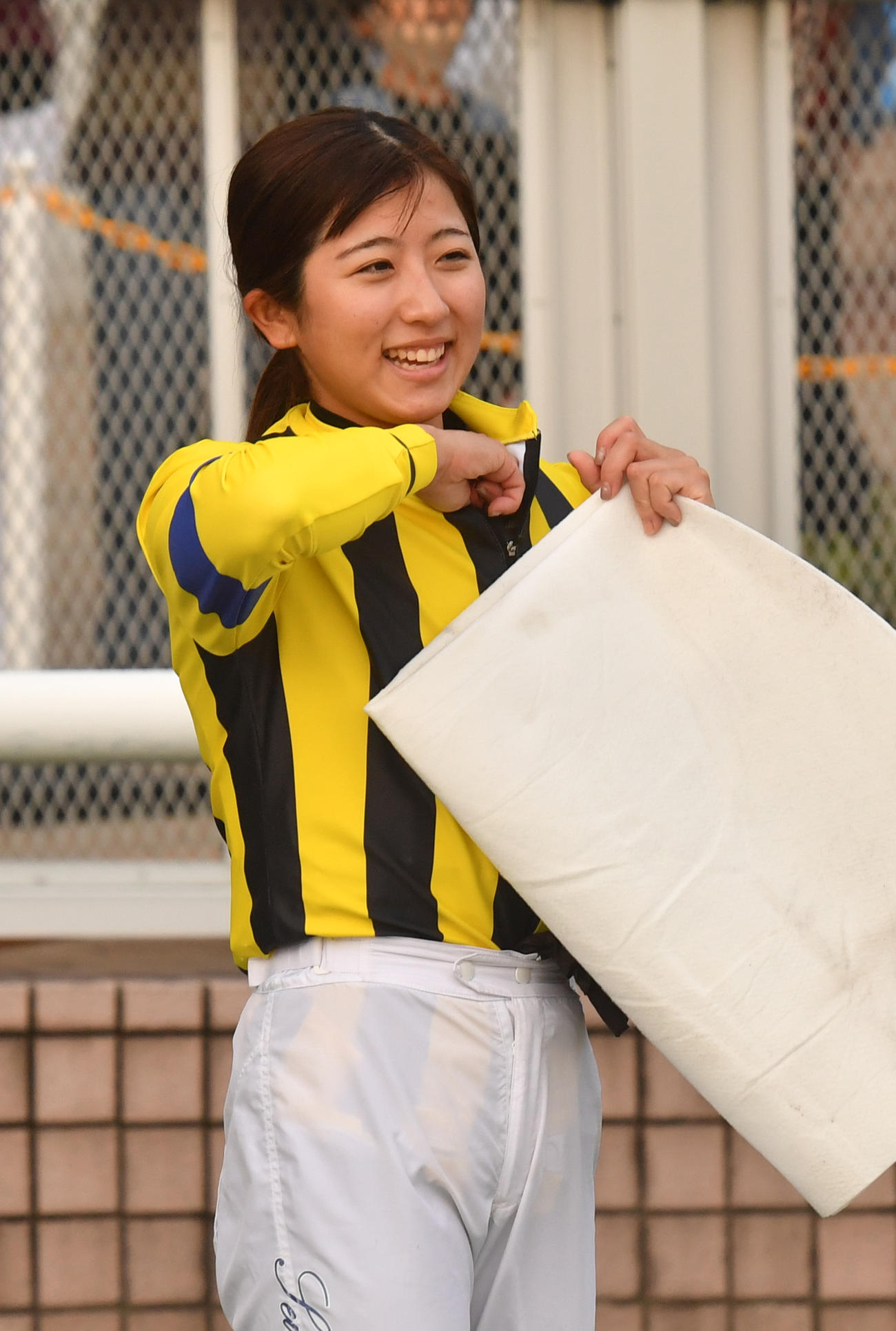 新潟12R、JRA女性騎手年間最多勝タイの43勝を挙げた今村騎手は笑顔を見せる（撮影・柴田隆二）