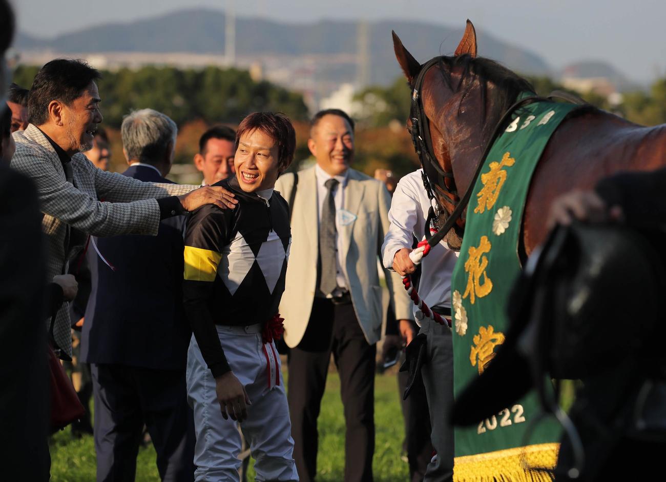 23日、アスクビクターモアで菊花賞を制した田辺騎手（右）は広崎オーナーからねぎらわれる