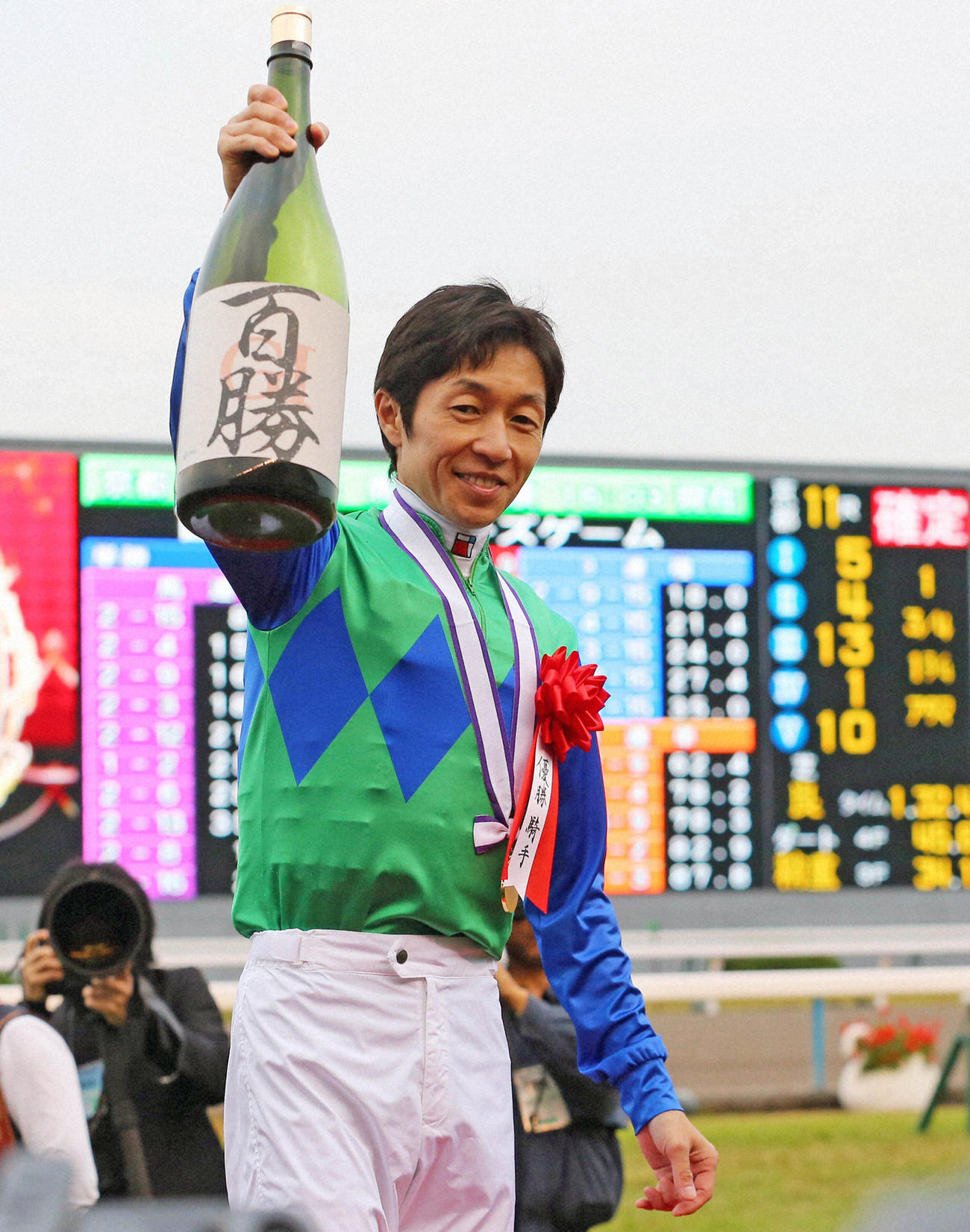 13年11月、武豊騎手はG1通算100勝を達成し、記念の一升瓶を掲げる