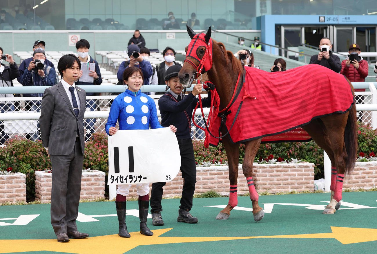 阪神2R、2歳未勝利を勝ち上がったタイセイランナーと口取りに並ぶ今村騎手（中央）（撮影・白石智彦）