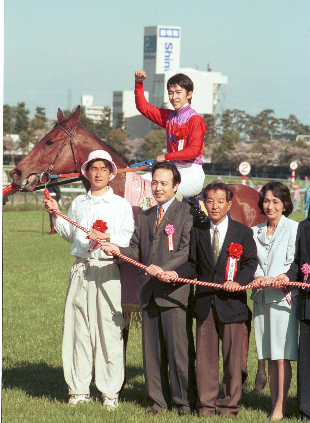 99年、桜花賞を制したプリモディーネと写真に納まる西橋師（右から2人目）。鞍上は福永騎手