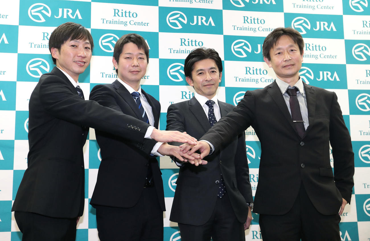 手を重ねて記念撮影に納まる左から、小椋助手、河嶋助手、福永騎手、藤野助手（撮影・白石智彦）