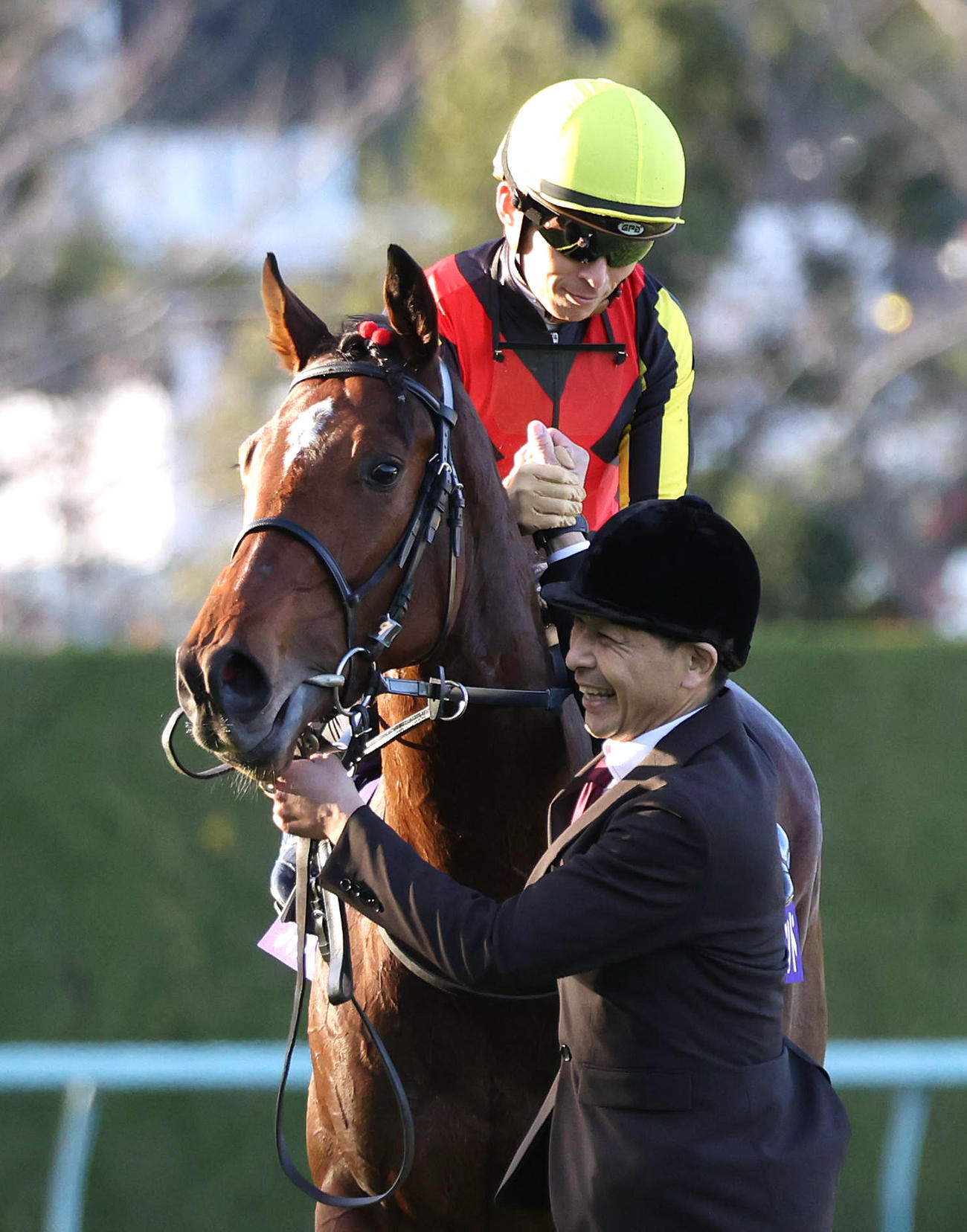 リバティアイランドで阪神JFを制して松崎助手（右）と力強く握手を交わす川田騎手（撮影・白石智彦）