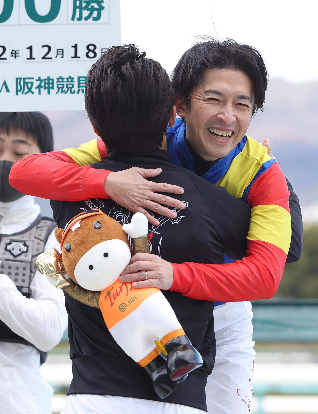 阪神9R、JRA年間100勝を達成した福永騎手（奥）は笑顔で川田騎手と抱擁を交わす（撮影・白石智彦）
