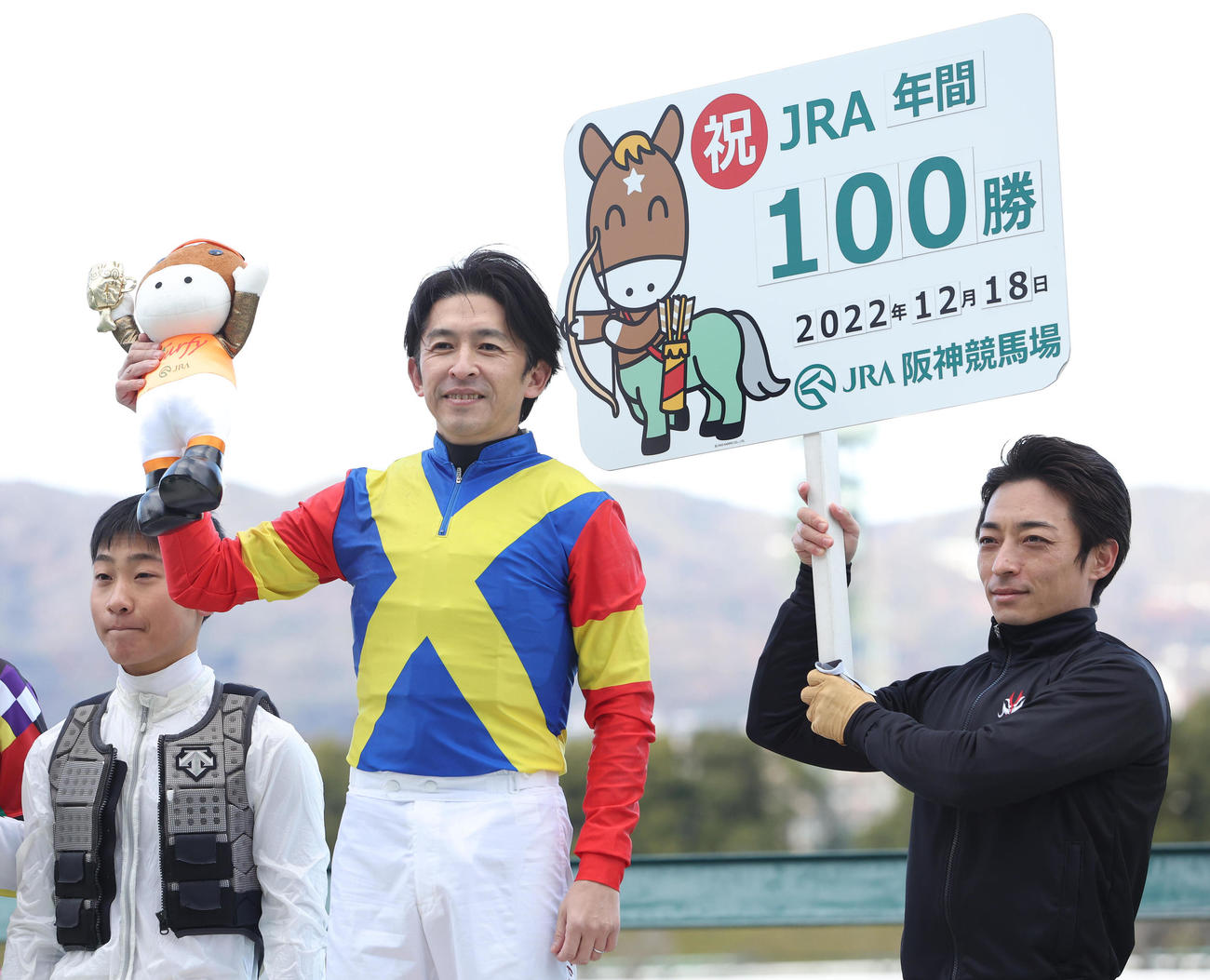 阪神9R、笑顔でターフィー人形を掲げるJRA年間100勝を達成した福永騎手（中央）（撮影・白石智彦）