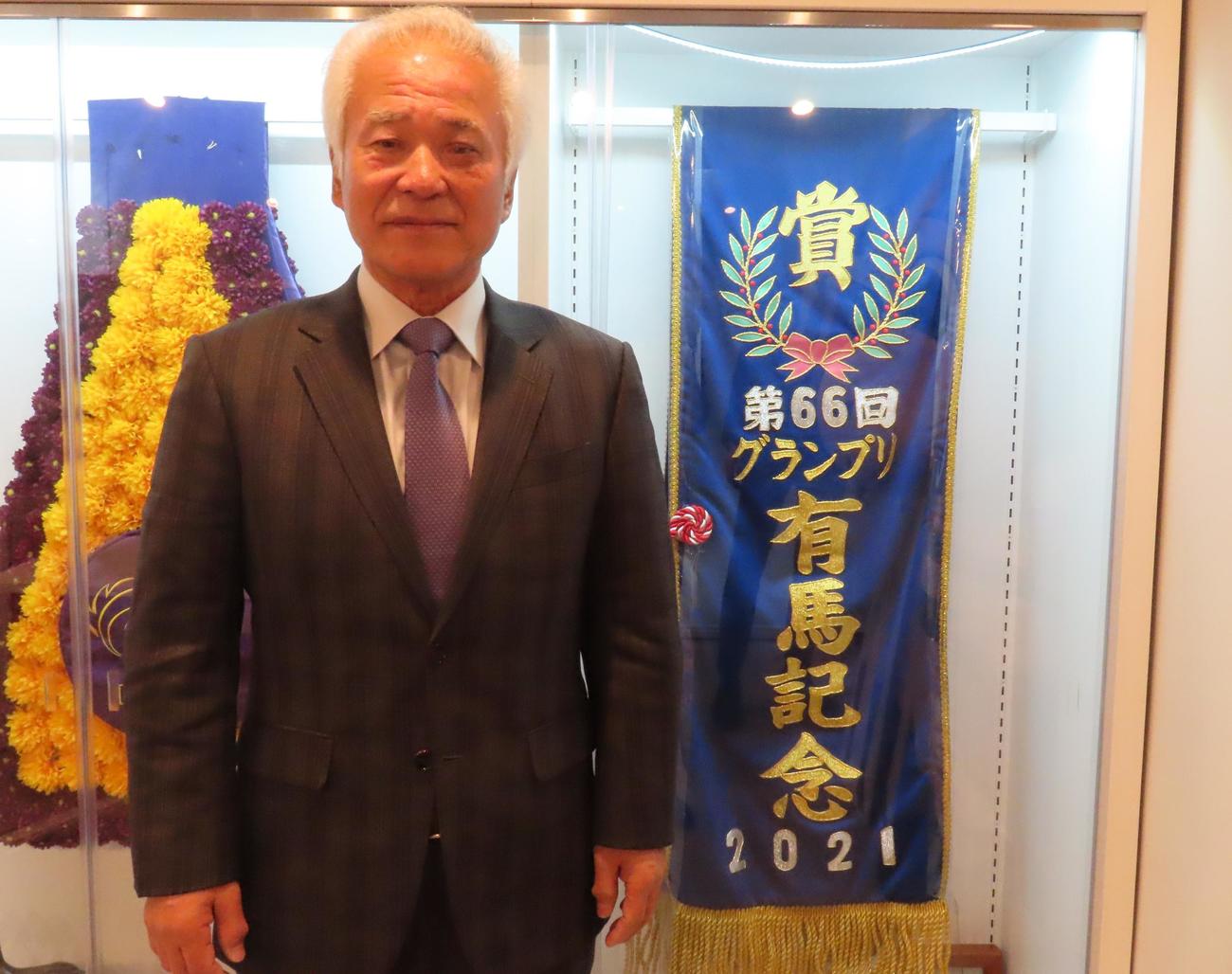 エフフォーリアの有馬記念優勝レイとともに写真におさまる、キャロットファーム秋田代表（撮影・阿部泰斉）