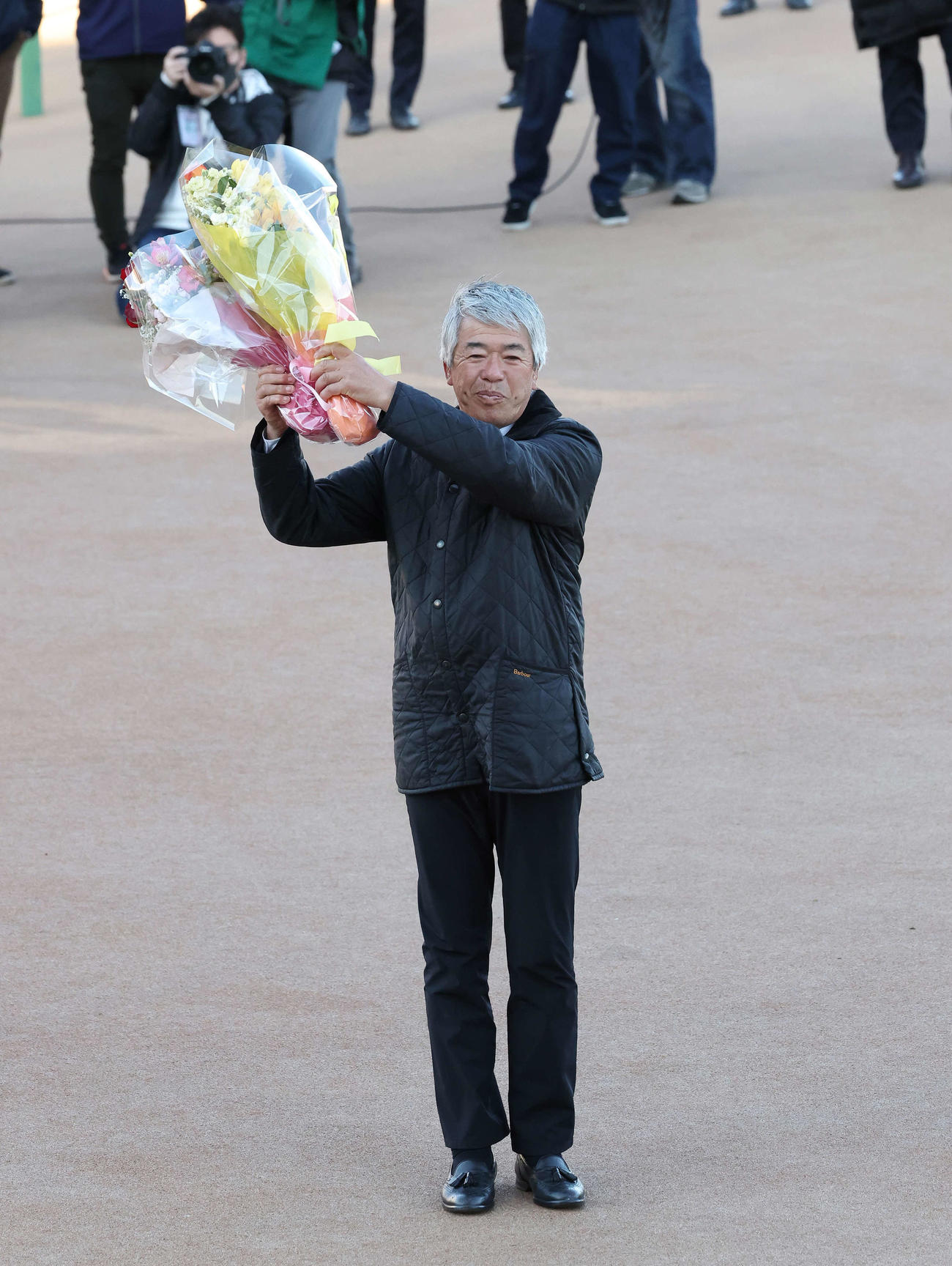 2月27日、中山で最後のレースを終えて花束を掲げる藤沢和調教師