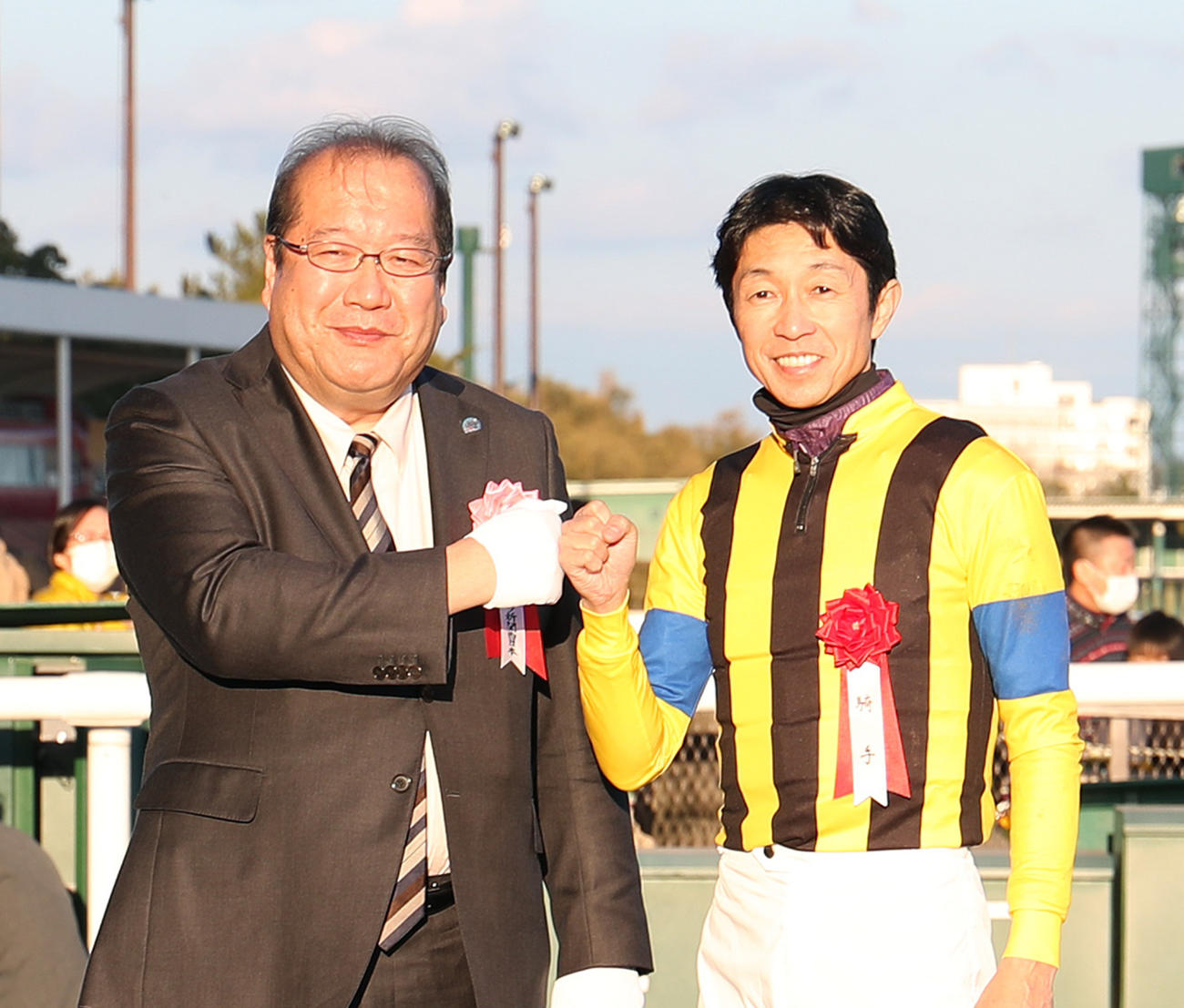 ライトクオンタムで日刊スポーツ賞シンザン記念を制した武豊騎手（右）は橘代表取締役社長とグータッチ