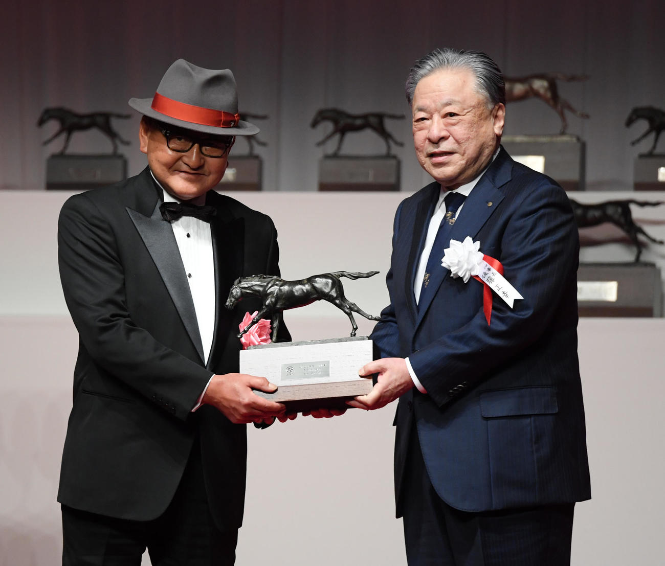 最多勝利、最多賞金獲得調教師に選ばれた矢作調教師（左）は後藤JRA理事長からトロフィーを贈られた
