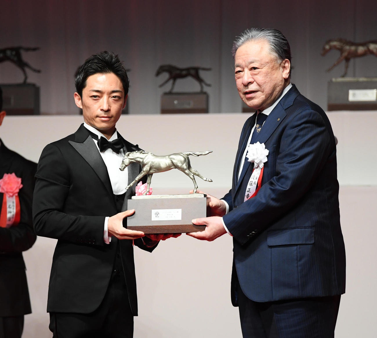 騎手大賞を受賞した川田騎手（左）は後藤JRA理事長からトロフィーを贈られた（撮影・柴田隆二）