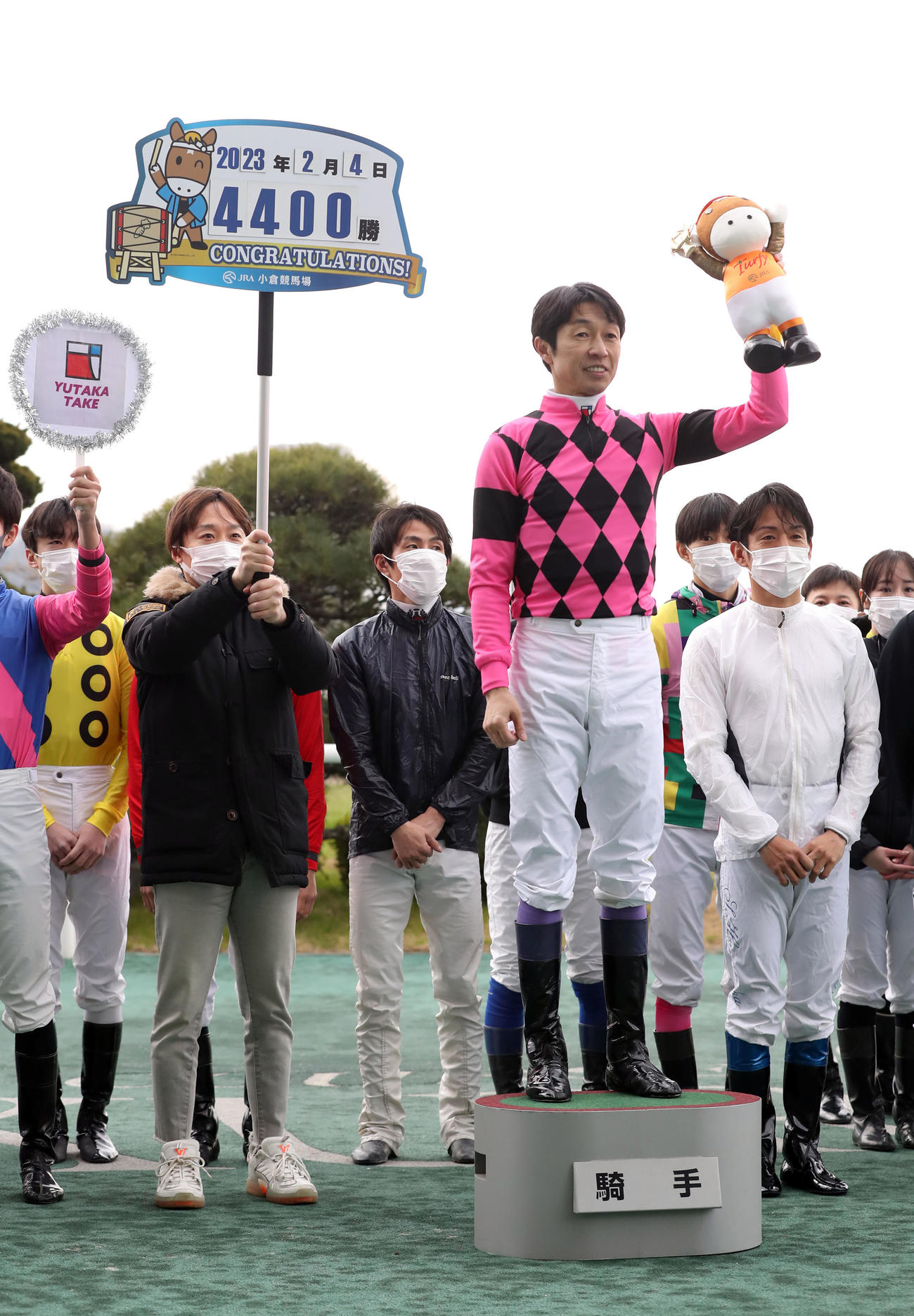 小倉1RでJRA通算4400勝を達成した武豊騎手。ボードを掲げるのは池添謙一騎手（撮影・屋方直哉）
