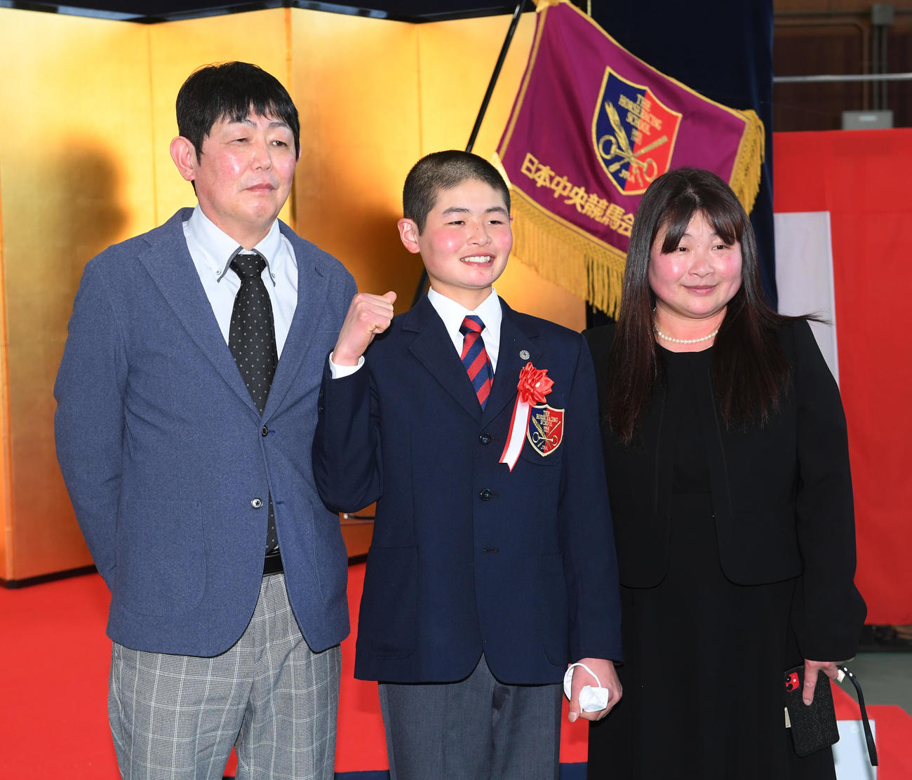 田口貫太騎手（中央）は父の輝彦調教師と母の広美元騎手と記念撮影する（撮影・柴田隆二）