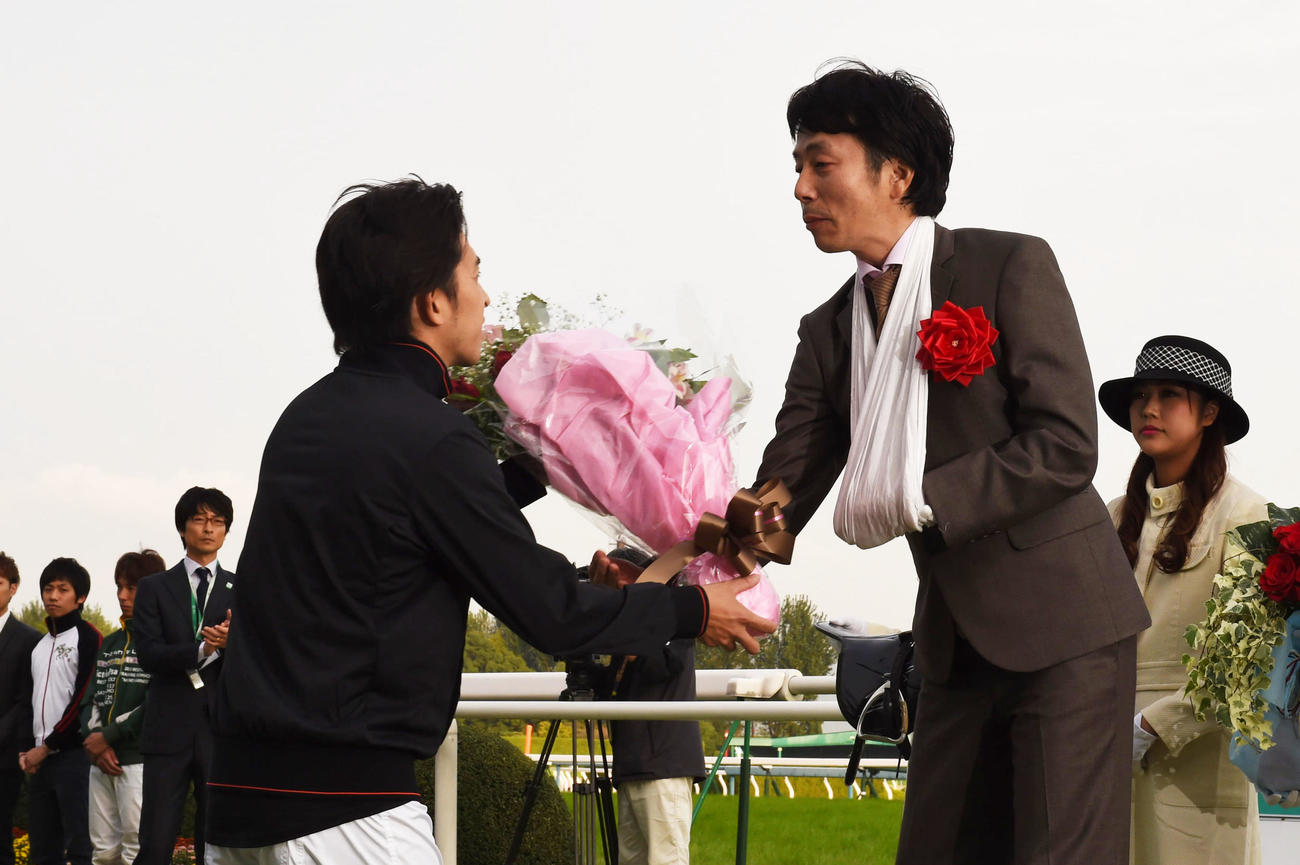 2014年10月、引退式で福永祐一騎手（左）から花束を贈られる佐藤哲三騎手