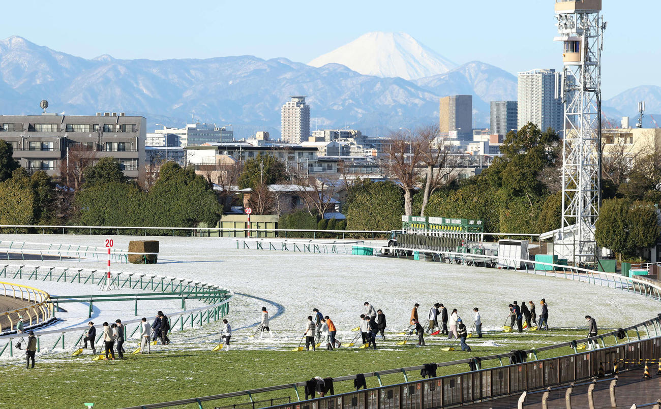 芝コースの除雪作業をする職員や係員（撮影・丹羽敏通）