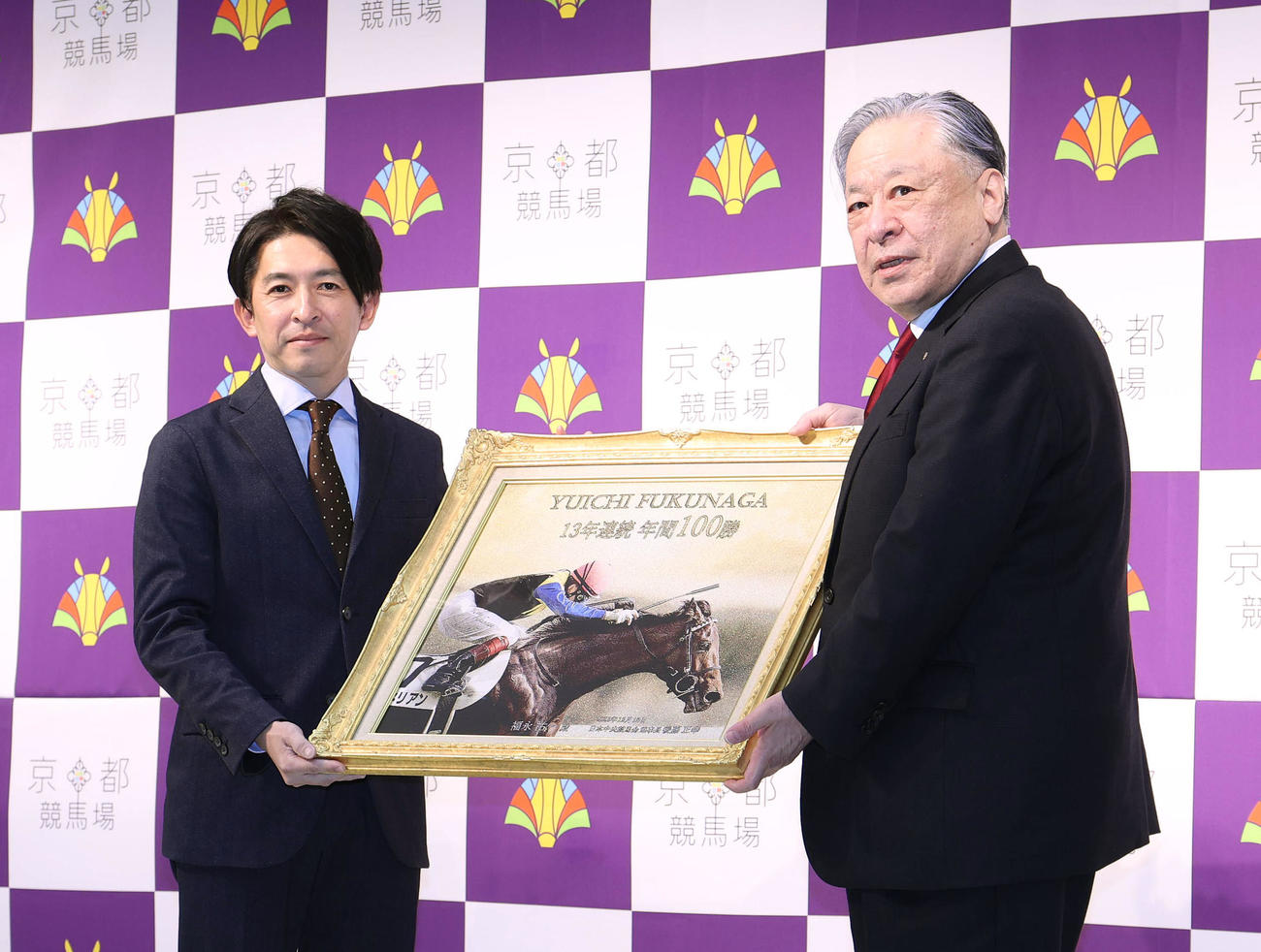 23年1月、理事長特別表彰セレモニーで後藤JRA理事長（右）から記念のパネルを贈呈される福永祐一騎手