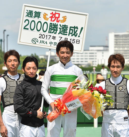 17年7月、JRA通算2000勝を達成し笑顔を見せる福永祐一騎手。ボードを掲げるのは川田騎手