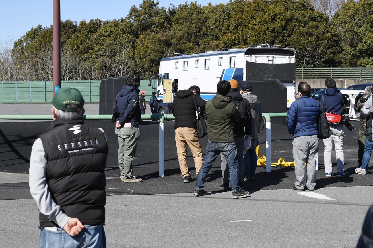 エフフォーリアを乗せた馬運車を見送る関係者と報道陣（撮影・柴田隆二）