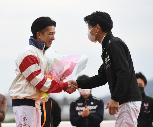 JRA最終騎乗後インタビューで、柴田善騎手から花束を贈られた福永騎手（左）（撮影・柴田隆二）