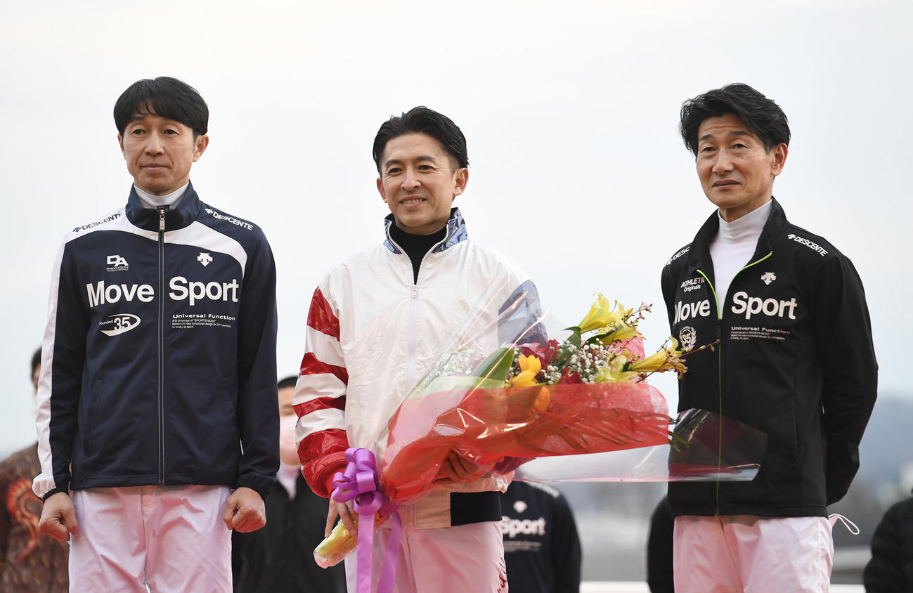 花束を贈られた福永騎手（中央）は武豊騎手（左）と柴田善騎手と記念撮影に納まる（撮影・柴田隆二）