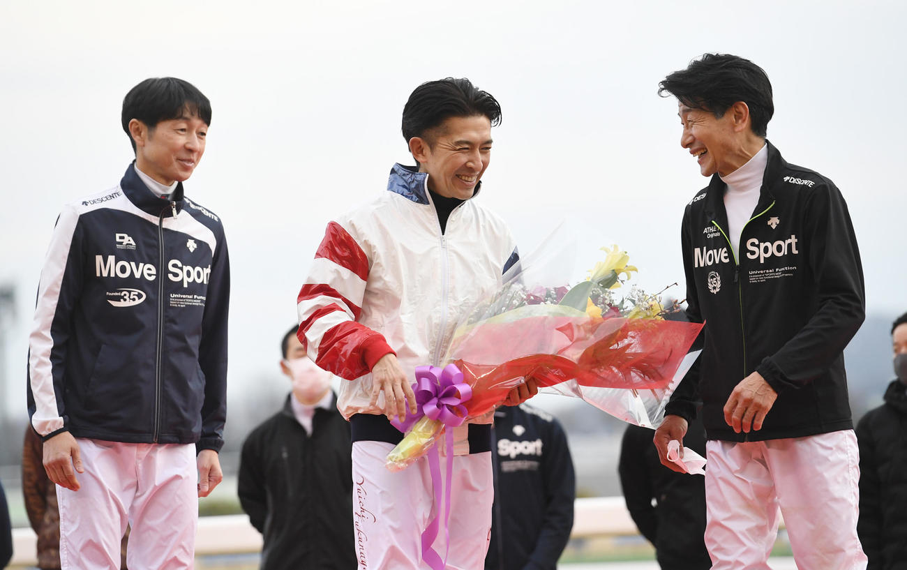 花束を贈られた福永騎手（中央）は武豊騎手（左）と柴田善騎手と笑顔を見せる（撮影・柴田隆二）